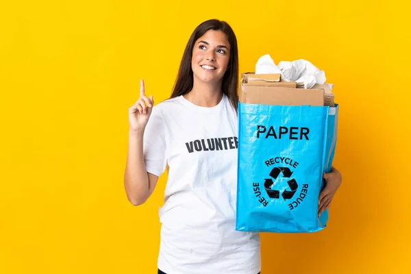 Młoda Brazylijska Dziewczyna Trzyma Worek Papierem Recyklingu Odizolowany Żółtym Tle — Zdjęcie stockowe
