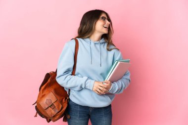 Pembe arka planda izole edilmiş genç bir bayan. Yan yana gülüyor.