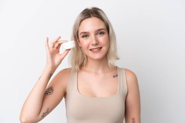 Beyaz arka planda nemlendirici ile izole edilmiş genç beyaz kadın.