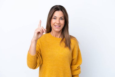Beyaz arka planda izole edilmiş orta yaşlı beyaz kadın harika bir fikre işaret ediyor.