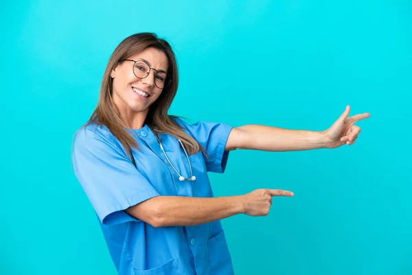 Chirurg Średnim Wieku Kobieta Odizolowana Niebieskim Tle Wskazując Palcem Bok — Zdjęcie stockowe