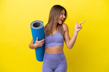 Spor kadını, elinde paspas tutarken yoga derslerine gidiyor. Sarı olmayan bir zemin tutuyor. Çözümün farkına varmak için parmağını kaldırıyor.