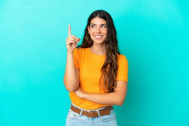 Mavi arka planda izole edilmiş beyaz bir kadın harika bir fikre işaret ediyor.