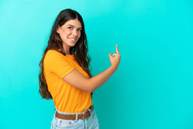 Kafkasyalı genç bir kadın mavi arka planda izole edilmiş.