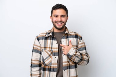 Genç Brezilyalı adam beyaz arka planda izole edilmiş, şaşırmış bir yüz ifadesi var.