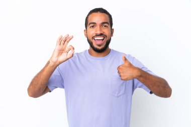 Beyaz arka planda izole edilmiş genç Ekvadorlu adam işaret ve baş parmak hareketi gösteriyor.
