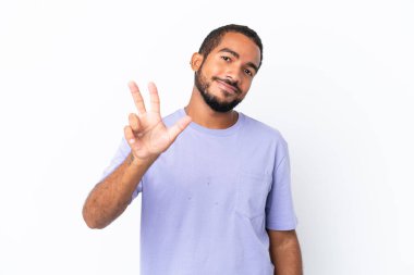 Genç Ekvadorlu beyaz arka planda izole edilmiş mutlu ve parmaklarıyla üçe kadar sayıyor.