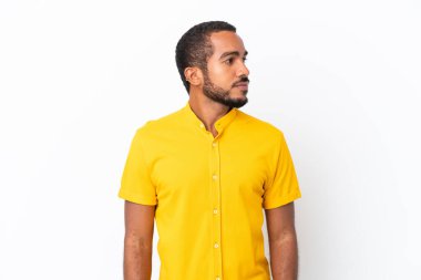 Genç Ekvadorlu adam beyaz arka planda izole edilmiş, yan tarafa bakıyor.