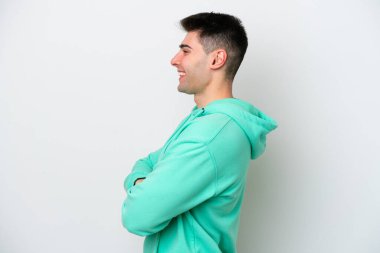 Beyaz arka planda beyaz tenli genç adam yan pozisyonda izole edildi.