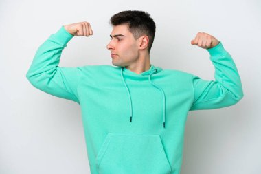 Beyaz arka planda izole genç beyaz adam güçlü jest yapıyor.