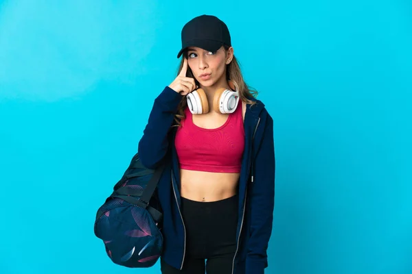 Νεαρή Αθλητική Γυναίκα Αθλητική Τσάντα Απομονωμένη Μπλε Φόντο Σκέφτεται Μια — Φωτογραφία Αρχείου