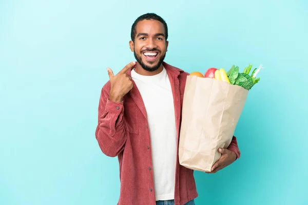 Joven Latino Sosteniendo Una Bolsa Compra Comestibles Aislado Sobre Fondo —  Fotos de Stock