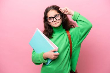 Pembe arka planda izole edilmiş küçük kız şüpheleri var ve kafası karışmış bir yüz ifadesi var.