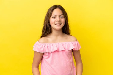 Sarı arka planda izole edilmiş küçük beyaz kız gülüyor.