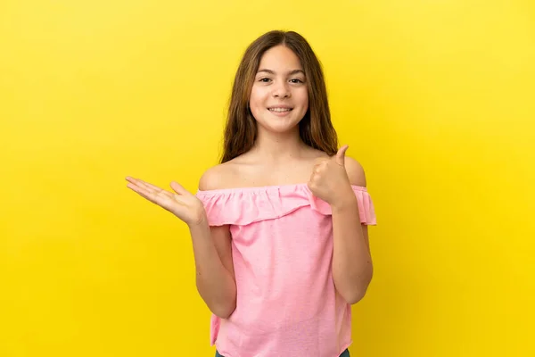 배경에 고립된 코카서스 소녀가 손바닥 공간을 광고를 삽입하고 엄지손가락을 올리고 — 스톡 사진