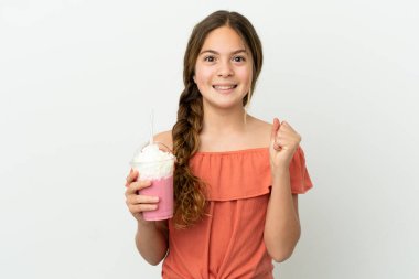 Beyaz arka planda izole edilmiş çilekli milkshake 'li küçük beyaz kız galibiyeti kutluyor.