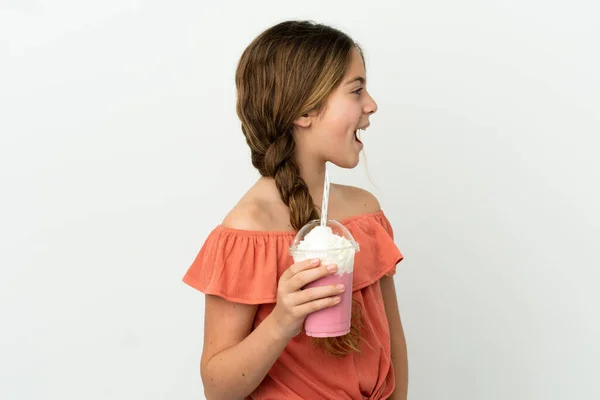 小さいですCaucasian女の子とともにイチゴミルクセーキ絶縁上の白い背景笑いで横位置 — ストック写真