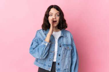 Pembe arka planda izole edilmiş genç Ukraynalı kız ağzı açık bağırıyor.