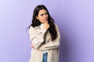 Mor arka planda izole edilmiş beyaz bir kadın. Şüpheleri var.