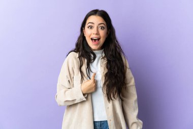 Mor arka planda yüzü sürpriz bir ifadeyle izole edilmiş beyaz bir kadın.