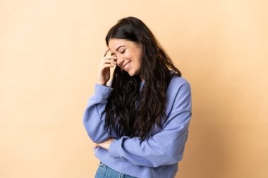 Kafkasyalı genç bir kadın soyutlanmış arka planda gülüyor.