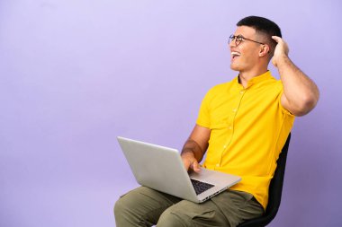 Dizüstü bilgisayarlı bir sandalyede oturan genç adam bir şeyin farkına vardı ve çözüme niyetlendi.