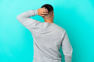 Soyutlanmış mavi arka planda genç yakışıklı bir adam.