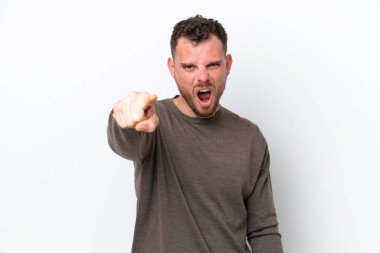 Beyaz arka planda izole edilmiş genç Brezilyalı adam hayal kırıklığına uğramış ve ön tarafı işaret ediyor.