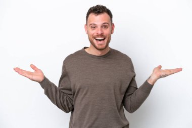 Yüzünde şok ifadesi olan beyaz arka planda izole edilmiş genç Brezilyalı bir adam.