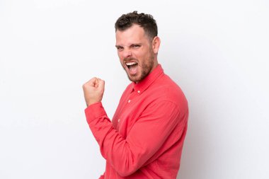 Genç Brezilyalı izole edilmiş beyaz arka planda zaferi kutluyor.