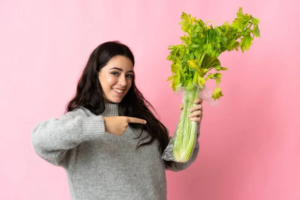 Giovane Donna Caucasica Che Tiene Sedano Isolato Sfondo Blu Indica — Foto Stock