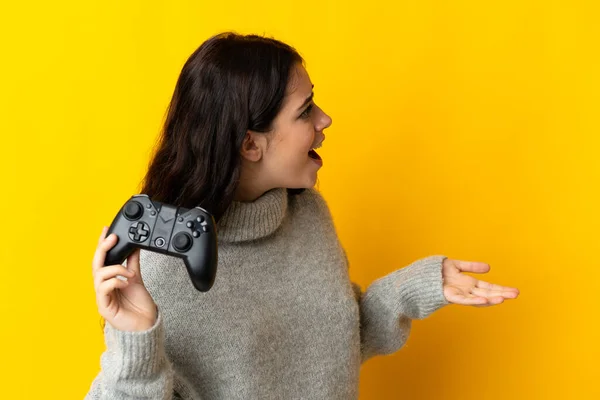 비디오 게임을 여자가 표정으로 노란색 배경에서 고립되었다 — 스톡 사진