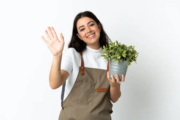 Mladá Běloška Drží Rostlina Izolované Bílém Pozadí Salutování Rukou Šťastným — Stock fotografie