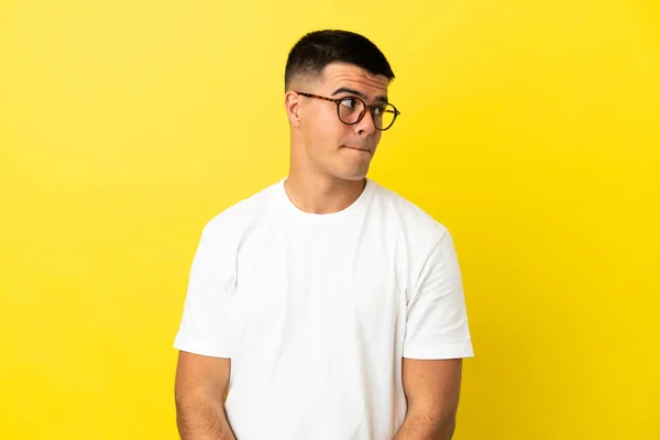Young Handsome Man Isolated Yellow Background Having Doubts While Looking — Stock Photo, Image