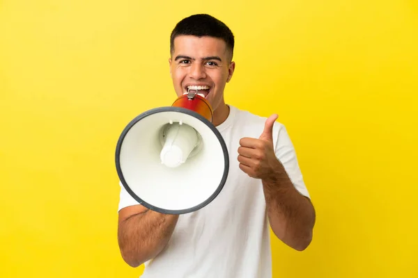 Jonge Knappe Man Geïsoleerde Gele Achtergrond Schreeuwt Door Een Megafoon — Stockfoto