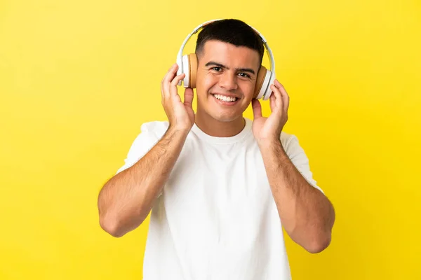 Jovem Homem Bonito Sobre Isolado Fundo Amarelo Ouvindo Música — Fotografia de Stock