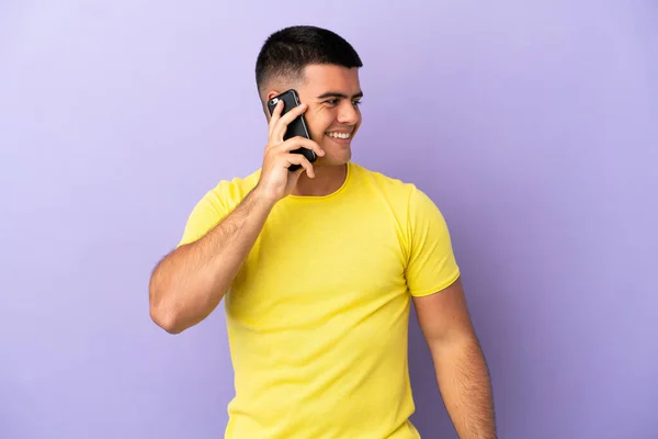 Joven Hombre Guapo Utilizando Teléfono Móvil Sobre Fondo Púrpura Aislado —  Fotos de Stock