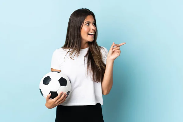 年轻的足球运动员巴西女孩被蓝色背景隔离 想在举手表决的同时实现这个解决方案 — 图库照片