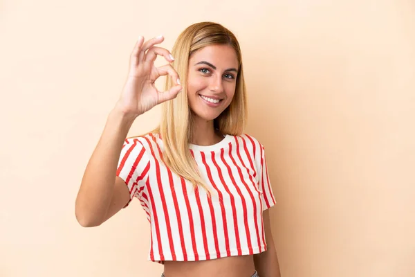 Blond Uruguayansk Flicka Isolerad Beige Bakgrund Visar Tecken Med Fingrar — Stockfoto