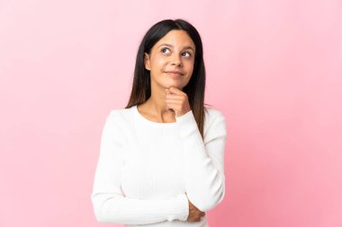 Beyaz kız pembe arka planda izole edilmiş ve yukarı bakıyor.