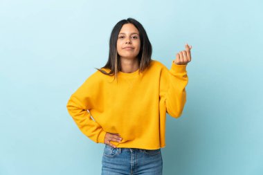 Mavi arka planda izole edilmiş beyaz bir kız İtalyan jesti yapıyor.