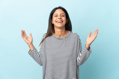 Mavi arka planda izole edilmiş beyaz bir kız. Çok gülümsüyor.