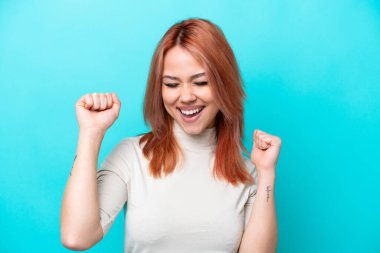 Mavi arka planda izole edilmiş genç Rus kadın zaferi kutluyor.