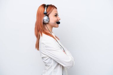 Tele pazarlamacı Rus kız kulaklıkla çalışıyor. Beyaz arka planda, yan pozisyonda izole edilmiş.