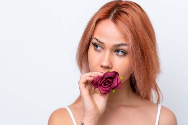 Beyaz arka planda çiçek tutan genç bir Rus kız. Portreyi kapat