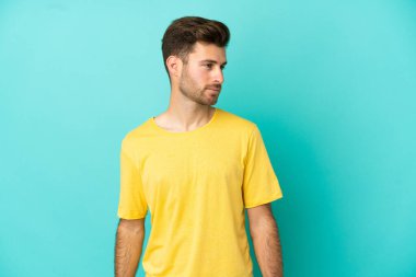 Beyaz tenli yakışıklı adam mavi arka planda izole edilmiş.