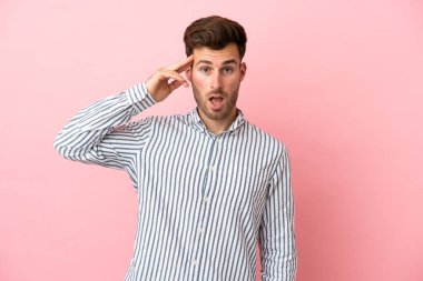 Pembe arka planda yaşayan beyaz tenli yakışıklı bir adam bir şey fark etti ve çözümü arıyor.