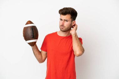 Beyaz arka planda ragbi oynayan Kafkasyalı genç adamın şüpheleri var.