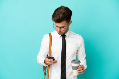 İş adamı izole edilmiş arka planda kahve ve cep telefonu tutuyor.