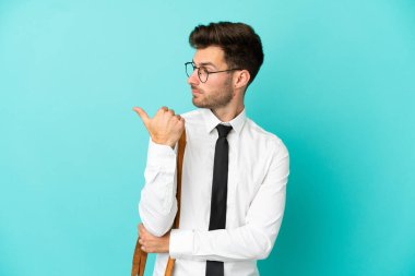 İzole edilmiş arka planda iş adamı bir ürünü sunmak için kenarı işaret ediyor.